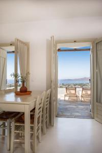 una sala da pranzo con tavolo e vista sull'oceano di Lithos Villas a Karistos