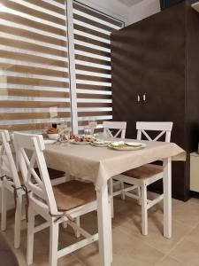 a white dining room table with white chairs at Belisima 204 B in Ravda