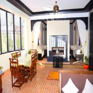 a living room with a table and a fireplace at Riad Dar Biona Maison D'hôtes & Spa in Aït Zat