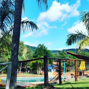ein Resort mit Pool und Palmen in der Unterkunft Locação De Barracas EcoPark in São Pedro