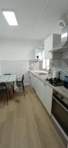 uma cozinha com um lavatório e um fogão forno superior em La Casona VIVIENDA USO TURÍSTICO RECIÉN REFORMADA EN EL CENTRO DE VILAGARCÍA. em Vilagarcía de Arousa