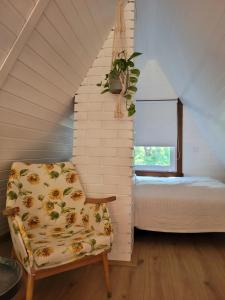 ein kleines Dachzimmer mit einem Stuhl und einem Bett in der Unterkunft Tobozka Vendégház in Noszvaj