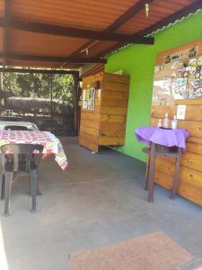 Zimmer mit einem Tisch und einer grünen Wand in der Unterkunft Locação De Barracas EcoPark in São Pedro