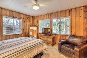een slaapkamer met een bed, een stoel en een televisie bij Idyllwild-Pine Cove Cabin with Expansive Deck! in Idyllwild