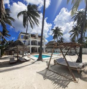 a resort with a swimming pool and palm trees at Coco Rise Villas - Villa Dining Service Available in Bwejuu