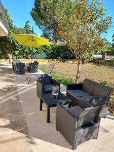 a patio with chairs and a table and an umbrella at Chez Kaïs in Avignon