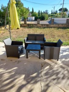 a patio with two chairs and a table and an umbrella at Chez Kaïs in Avignon