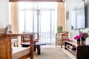 a living room with a couch and a table at Coco Rise Villas - Villa Dining Service Available in Bwejuu