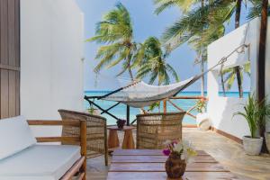 a porch with a hammock and the ocean at Coco Rise Villas - by Hostly in Bwejuu