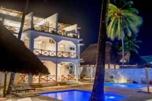 a resort with a swimming pool and a building at Coco Rise Villas - Villa Dining Service Available in Bwejuu