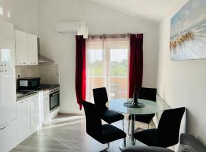 a kitchen with a table and chairs in a room at Apartman Tina in Murvica