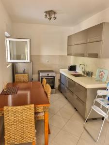 a kitchen with a wooden table and a counter top at Apartments Rales in Sveti Stefan