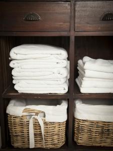 a rack of towels and baskets in a closet at El Requexu, apartamentos a 900 m de la playa de Poo in Llanes