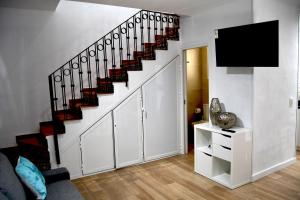 a living room with a staircase with a flat screen tv at Casa VALOLI PLAYA MIRAMAR in Miramar