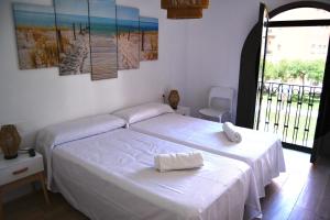 a bedroom with two beds and a large window at Casa VALOLI PLAYA MIRAMAR in Miramar
