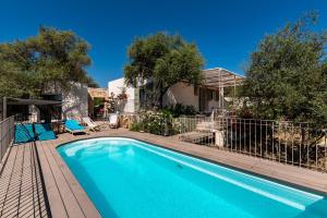 una piscina con sillas azules y árboles en La Maison des Oliviers - Belle maison familiale avec Piscine, en Occhiatana