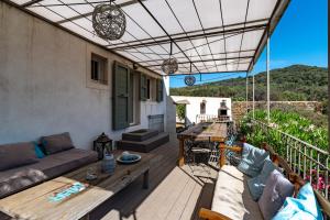 un patio con sofá y mesa en La Maison des Oliviers - Belle maison familiale avec Piscine, en Occhiatana