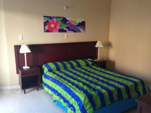 a bedroom with a bed with a colorful striped blanket at Hotel Betoma in Santa Marta