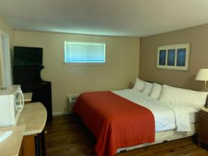 a hotel room with a large bed and a piano at Beachway Motel in Salisbury