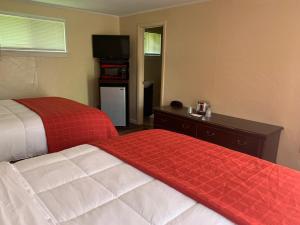 a hotel room with two beds and a television at Beachway Motel in Salisbury