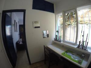 baño con encimera, espejo y ventana en Hostel Cultural Casa Taller en Bahía Blanca