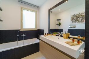 łazienka z umywalką, wanną i lustrem w obiekcie Villa Vittoria - Waterfront house w Auguście