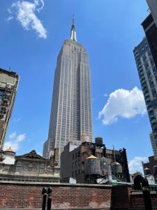 a tall building with a cross on top of it at Hotel and the City, Rooftop City View in New York