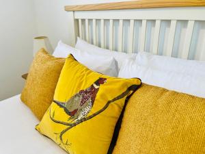 a bed with two pillows with a chicken on it at Grassington Cottage in Grassington