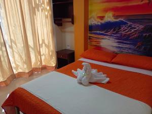 Hostal Bryana Inn Baños tesisinde bir odada yatak veya yataklar