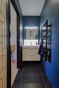 La salle de bains bleue est pourvue d'un lavabo et d'un miroir. dans l'établissement Le lodge de Fourvière, à Lyon