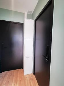 an empty room with a black door and wooden floors at Le lodge de Fourvière in Lyon