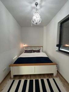 sypialnia z łóżkiem i żyrandolem w obiekcie Sprezzatura Apartament w mieście Agigea