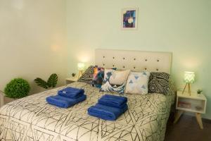 una camera da letto con un letto con cuscini blu di Beautiful quiet apartment near A. Villanueva St a Mendoza