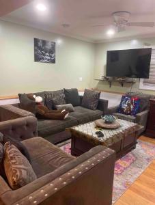 a living room with couches and a flat screen tv at Guest Room in Eatontown