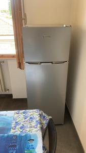 a silver refrigerator in a kitchen with a table at Appartamento Marina Centro Mare in Rimini