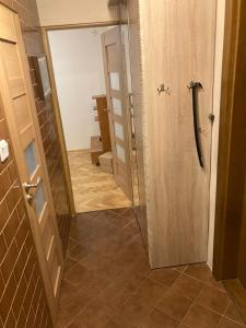 ein Bad mit einer Tür, die auf einen Flur führt in der Unterkunft Apartament Roma in Danzig