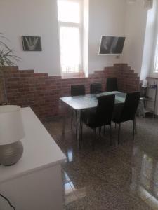 een tafel en stoelen in een kamer met een bakstenen muur bij Villa Pelda Apartment, sea view, parking, pet friendly in Opatija