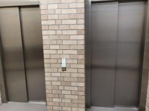 two metal elevators on a wall in a building at Apartament Wrzeszcz, blisko morza in Gdańsk