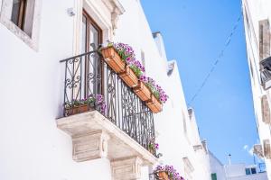 - un balcon fleuri sur le côté du bâtiment dans l'établissement Domus San Giovanni, à Locorotondo