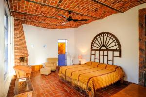 a bedroom with a bed and a brick wall at Casa Aurora in Ajijic