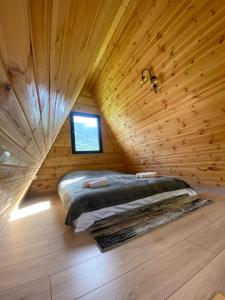 um quarto com uma cama num chalé de madeira em Labna Huts em Mestia