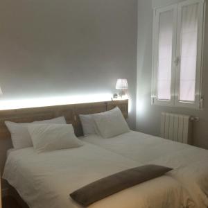 a bedroom with a large white bed with a large pillow on it at diezmadrid in Madrid