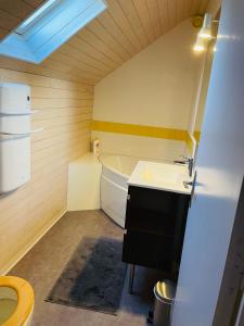 a small bathroom with a tub and a sink at Maison des Coteaux blancs in Chaudefonds-sur-Layon +30 photos