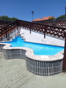a swimming pool with a wooden bridge over it at Apartamento Noja Beach in Noja