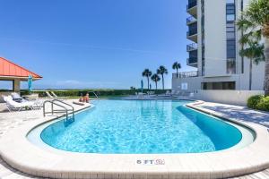 a swimming pool at a resort with palm trees at 1506 Lighthouse Towers in Clearwater Beach