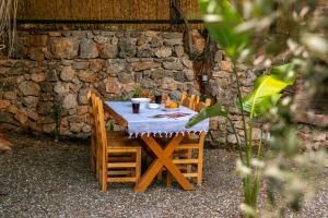 einem Holztisch mit Stühlen und einem Tisch mit Orangen darauf in der Unterkunft Gokova Dag Evleri in Kuyucak