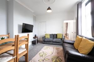 a living room with a couch and a table at Spacious & Homely, 4 BR, Parking, Close to Centre in Sheffield