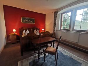 ein Wohnzimmer mit einem Klavier und einer roten Wand in der Unterkunft Ruhige Ferienwohnung im Gutshaus in Niederorschel