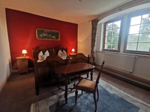 un soggiorno con pianoforte e parete rossa di Ruhige Ferienwohnung im Gutshaus a Niederorschel