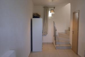 a white refrigerator in a hallway with stairs at Ateni House in Agios Petros +75 photos